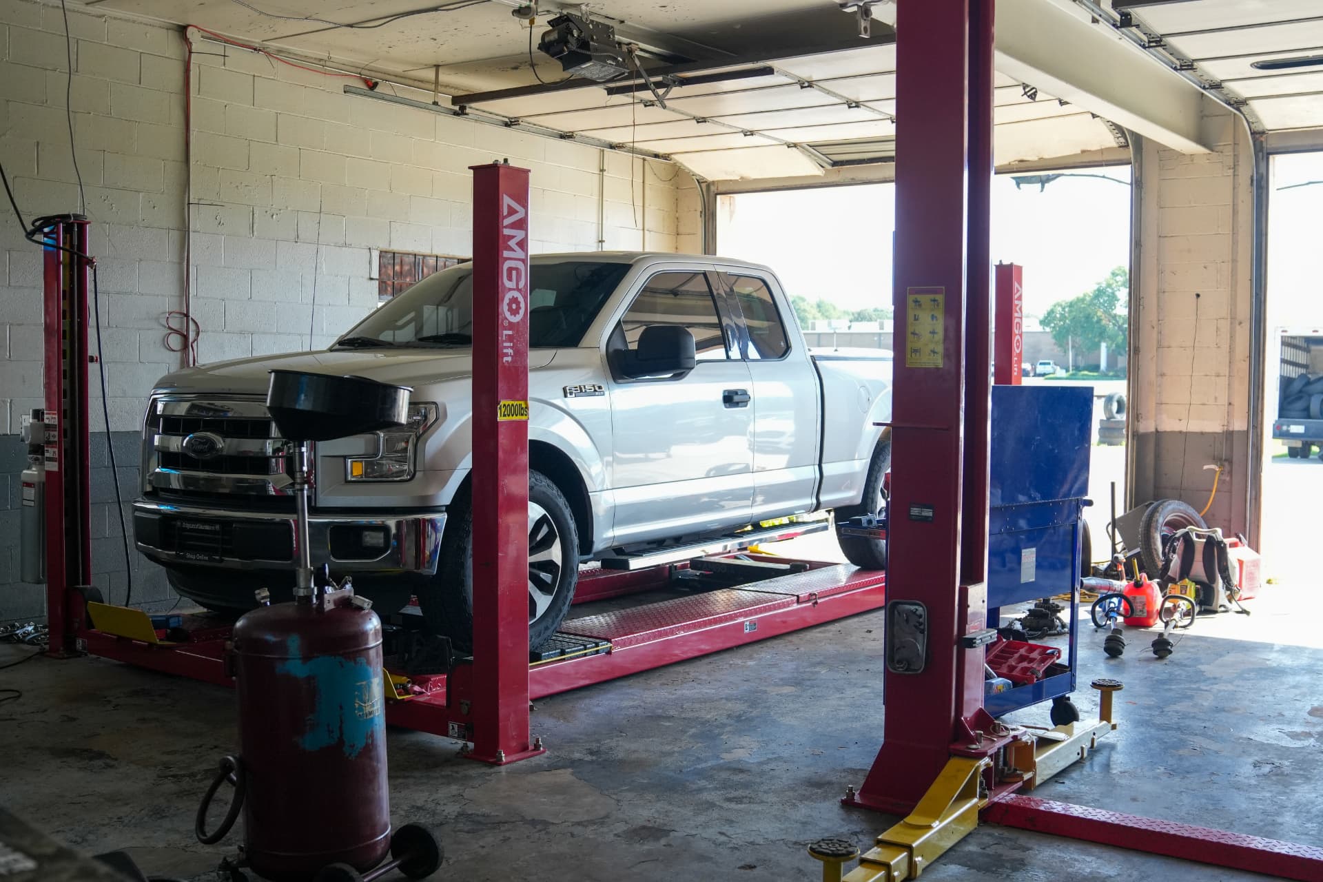 Ford F-150 raised on the alignment lift in the shop